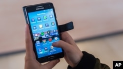 A woman uses an Android smartphone in Brussels on April 20, 2016. The European Union is broadening its battle with Google, alleging that the technology giant rigs the global market for mobile apps by making its Android operating system give preferential treatment to its own products.