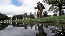 미국의 현충일인 '메모리얼데이'를 앞둔 지난 23일 미군들이 알링턴 국립묘지 내 전사자 묘비에 성조기를 설치하고 있다.