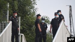 安全人员守卫在北京新发地市场附近的行人天桥。(2020年6月13日)