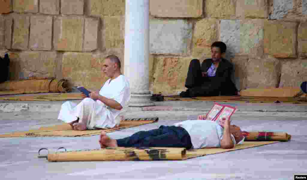 Des Musulmans lisent le Coran à l'intérieur de la mosquée Zitouna pendant le ramadan à Tunis, en Tunisie, le 15 juin 2016.