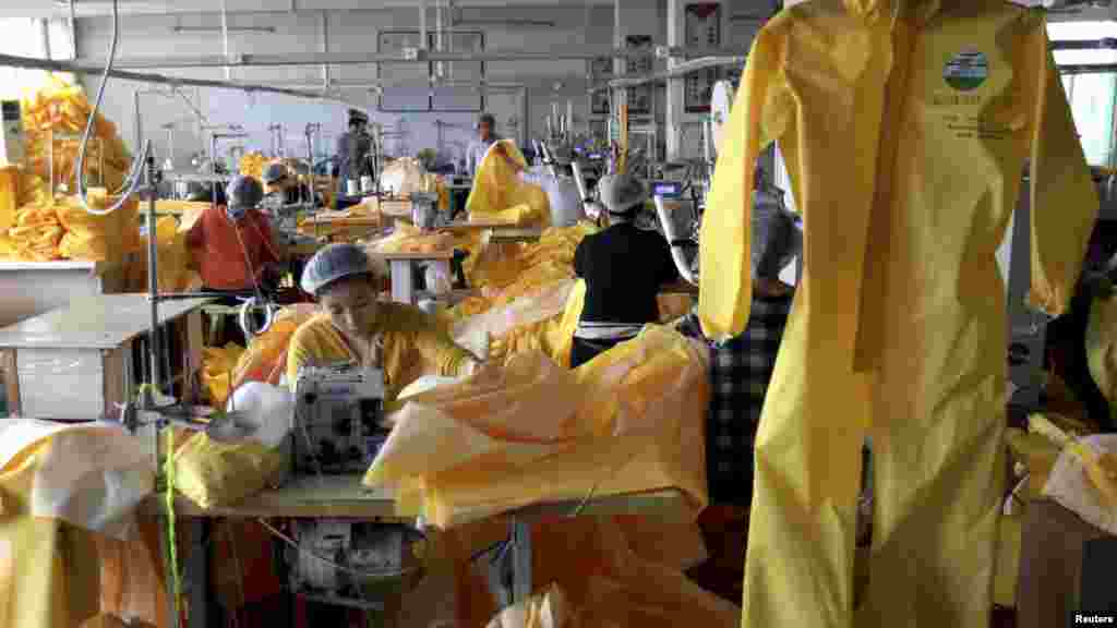 Workers make protective clothing at a factory of Lakeland Industries in Weifang, Shandong province, Oct. 28, 2014. 