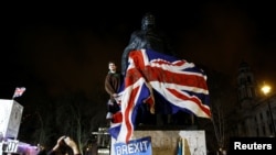 La gente celebra ante la estatua de Winston Churchill el día del Brexit en Londres, Reino Unido, el 31 de enero de 2020.