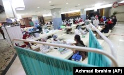 Para pedagang di Pasar Tanah Abang menerima suntikan vaksin COVID-19 dalam kegiatan vaksinasi massal, Jakarta, 18 Februari 2021. (Foto: Achmad Ibrahim/AP)