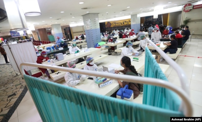 Para pedagang di Pasar Tanah Abang menerima suntikan vaksin COVID-19 dalam kegiatan vaksinasi massal, Jakarta, 18 Februari 2021. (Foto: Achmad Ibrahim/AP)