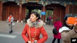 游人在北京大学入口拍照留念（2014年11月20日资料照）