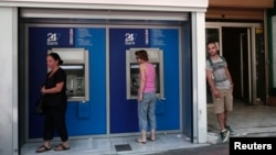 12일 그리스 아테네의 한 은행 지점에서 현금을 찾는 주민들.