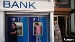 Warga melakukan transaksi di ATM di Athena, Yunani. (Foto: Dok)