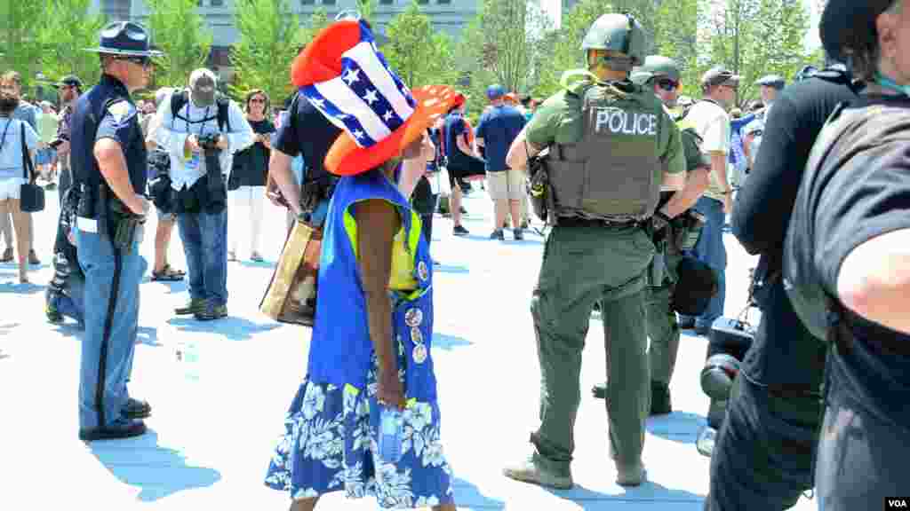 Woman walks among police at the Republican National Convention in Cleveland (July 19, 2016).