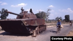 A broken tank used in the civil war was abandoned on a road near the capital in 1980, Phnom Penh, Cambodia. (Courtesy John Burgess)