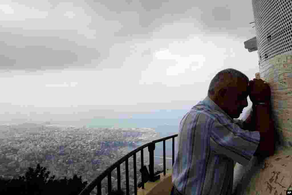 A pilgrim prays at the feet of a shrine to the Virgin Mary in Harissa, near Beirut, Lebanon, Lebanon.