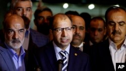 Iraqi parliament speaker Salim al-Jabouri, center, speaks to reporters during a news conference in Baghdad, Iraq, April 13, 2016. 