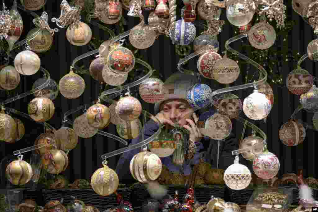 A vendor speaks on the phone at a Christmas market in Vienna, Austria, Nov. 20, 2021.