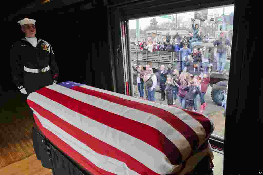 The flag-draped casket of former President George H.W. Bush passes through Magnolia, Texas, along the route from Spring to College Station, Texas, Dec. 6, 2018.