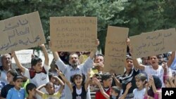 ພວກອົບພະຍົບຊີເຣຍພາກັນຍົກປ້າຍປະທ້ວງ ຊຶ່ງປ້າຍແຜ່ນທີ 2 ຈາກຊ້າຍກ່າວວ່າ ປົກປ້ອງເມືອງ Jisr al-Shughour ຈາກ Bashar al-Assad ຂອບໃຈທ່ານ Erdogan ແຫ່ງເຕີກກີ (10 ມິຖຸນາ 2011)