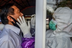 Petugas medis mengambil sampel usap dari seorang petugas untuk mencegah penyebaran Covid-19 di Palu, Provinsi Sulawesi Tengah, 3 Juni 2020. (Foto: Antara/Basri Marzuki via REUTERS)