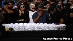 Relatives and friends mourn next to the coffin of Brazilian singer Marilia Mendonca, during her wake at the Arena Goiania sports center, in Goiania, state of Goias, Brazil, Nov. 6, 2021. Mendonca died in a plane crash on her way to a performance Friday.