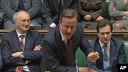 Britain's Prime Minister David Cameron (C) is flanked by Chancellor of the Exchequer George Osborne (R) and Leader of the House of Commons George Young during a parliamentary debate on last week's European Union summit, in London, December 12, 2011.