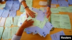 Members of an election office sort ballots in Zurich, Switzerland, Sept. 24, 2017. 