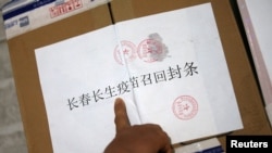 中国长春疾病控制中心的工作人员在召回的长春长生公司生产的狂犬病疫苗箱子上贴封条。（2018年7