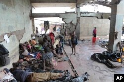 Survivors of Cyclone Idai wait in an abandoned and derelict building near Nhamatanda, about 50 kilometers from Beira, in Mozambique, March, 22, 2019.