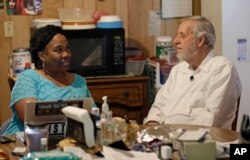FILE - Civil rights attorney Al McSurely and his wife, O'Linda Williams, sit together in the kitchen of their home in Carthage, N.C., June 6, 2018.