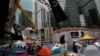 A man walks some tents set up by pro-democracy protesters in an occupied area outside government headquarters in Hong Kong's Admiralty district, Nov. 13, 2014.