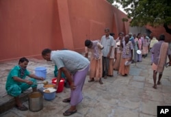 In this Nov. 13, 2017 photo, homeless people who were picked from the streets line up for food at Anand Ashram, a shelter home for male beggars in Hyderabad.