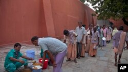 In this Nov. 13, 2017 photo, homeless people who were picked from the streets line up for food at Anand Ashram, a shelter home for male beggars in Hyderabad.