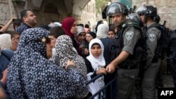 Muslim Palestina menunggu selagi penjaga perbatasan Israel memeriksa dokumen dan barang milik mereka di pintu masuk Masjid of al-Aqsa di Yerusalem, 20 April 2014.