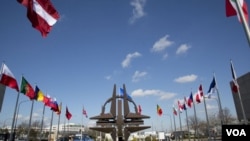 FILE - Flags of the NATO nations fly outside NATO headquarters in Brussels.