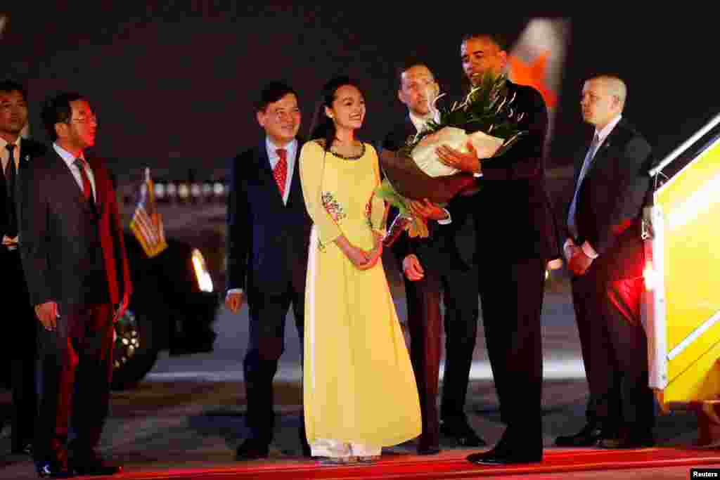 Tổng thống Obama nhận hoa khi bước xuống máy bay tại sân bay Nội Bài ở Hà Nội, tối ngày 22/5/2016. &nbsp;