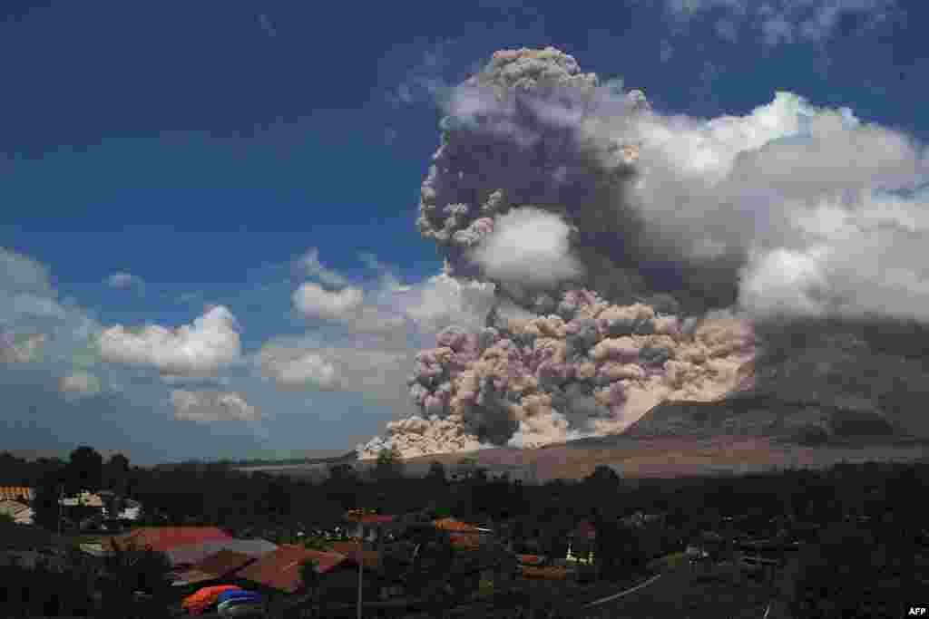 A super-heated giant ash cloud spews from the crater of Mount Sinabung volcano threatening villages during an eruption, as seen from Simpang Empat district on Sumatra island.