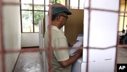 An East Timorese voter checks his ballot at a polling station during the presidential election in Dili, March 17, 2012. 