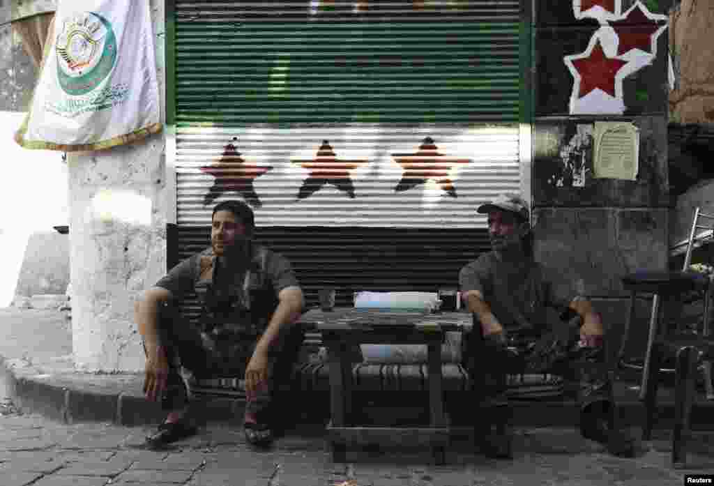 Free Syrian Army fighters sit at a checkpoint in the old city of Aleppo, August 20, 2013.