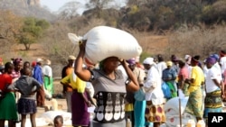 A woman carries a bag of maize distributed by the United Nations World Food Program (WFP) in Mwenezi, about 450 kilometers (280 miles) south of Harare, Zimbabwe, Sept. 9, 2015.