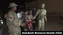 Somali security forces escort a man who was rescued from Pizza House. Somali security forces ended an al-Shabab siege of two Mogadishu restaurants early Thursday morning. About two dozen people were killed.