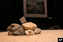 In this Oct. 10, 2017 photo, rocks from a cairn erected on Robben Island in South Africa rest in a display case at the Clinton Presidential Center in Little Rock, Ark., as part of the exhibit "Mandela: The Journey to Ubuntu."