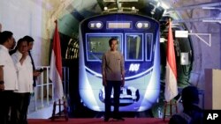 Presiden Joko Widodo berdiri di tengah panggung dengan latar kereta Moda Raya Terpadu (MRT) dalam upacara peresmian di Jakarta, Minggu, 24 Maret 2019.