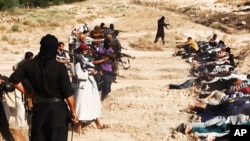 FILE - Image posted on a militant website on June 14, 2014, appears to show militants from the Islamic State group taking aim at captured Iraqi soldiers wearing plain clothes after taking over a base in Tikrit, Iraq. 