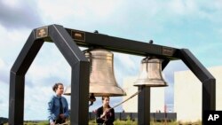 Matthew Prosser and Gina Rhoads of Shanksville-Stonycreek High School ring the Bells of Remembrance during the service of remembrance tribute to the passengers and crew of Flight 93 at the Flight 93 National Memorial in Shanksville, Pennsylvania (AP Photo/Jared Wickerham, File).