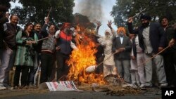 Sikh protestors burn effigies of congress party leaders Sajjan Kumar and Kamal Nath during a protest in New Delhi, India, Monday, Dec. 17, 2018.
