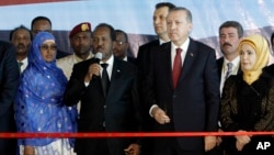 Turkey's President Recep Tayyip Erdogan, center, and Somalia President Hassan Sheikh Mohamud, second left, with their wives, attend the cutting of the tape for the new airport terminal in the capital Mogadishu, Jan. 25, 2015. 
