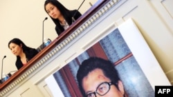 Vợ của nhà hoạt động nhân quyền Quách Phi Hùng (trái), và con gái của ông tại cuộc họp báo trước một cuộc điều trần của tiểu bang Đối Ngoại Hạ viện Hoa Kỳ trong thủ đô Washington, 29/10/13