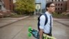 FILE - A student walks across campus at the University of Oregon in Eugene, Oregon.