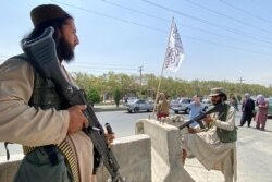 Pejuang Taliban berjaga di pintu masuk di luar Kementerian Dalam Negeri di Kabul, 17 Agustus 2021. (Foto: Javed Tanveer / AFP)