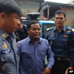 Military Police officers escort Mr. Chhoeun Vanthan, former bodyguard chief of Mr. Chea Sim, senate president, to Phnom Penh's municipal court on Monday, August 15, to be questioned about illegal weapons.