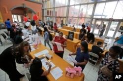 FILE - People attend a job fair at Dolphin Mall in Miami. The federal government issues its October jobs report Friday, Nov. 6, 2015.