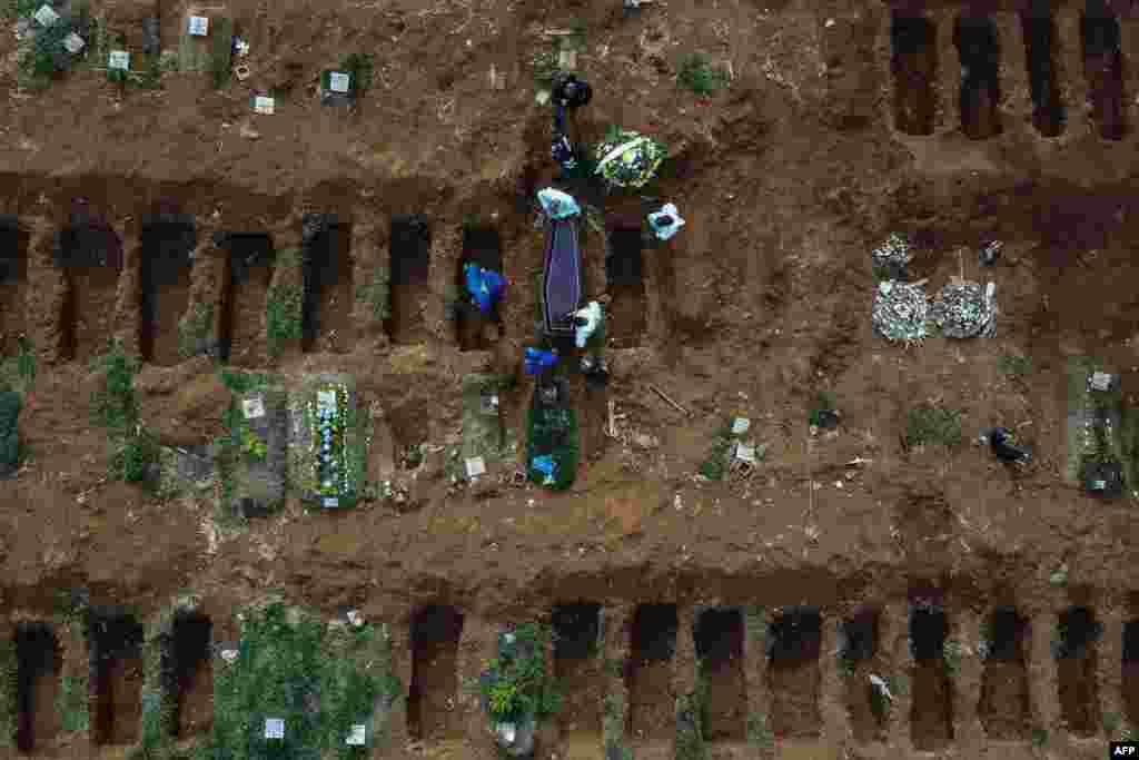 Grave diggers bury a possible COVID-19 victim at the Vila Formosa Cemetery, in the outer area of Sao Paulo, Brazil.