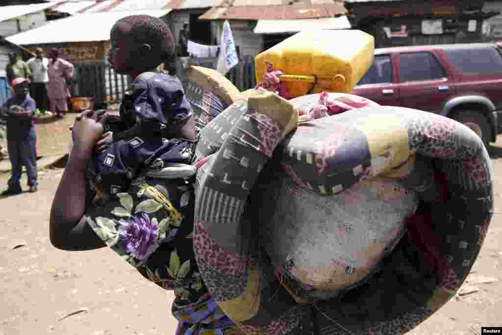 A woman carries her child in Minova, 45 kilometers west of Goma, DRC, November 26, 2012. 