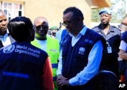 FILE - Dr. Tedros Adhanom Ghebreyesus, WHO director-general, center, speaks to a health official at a newly established Ebola response center in Beni, Democratic Republic of Congo, Aug. 10, 2018.